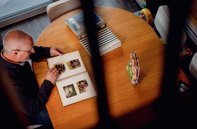 Scott Morrow at home browsing a photo album