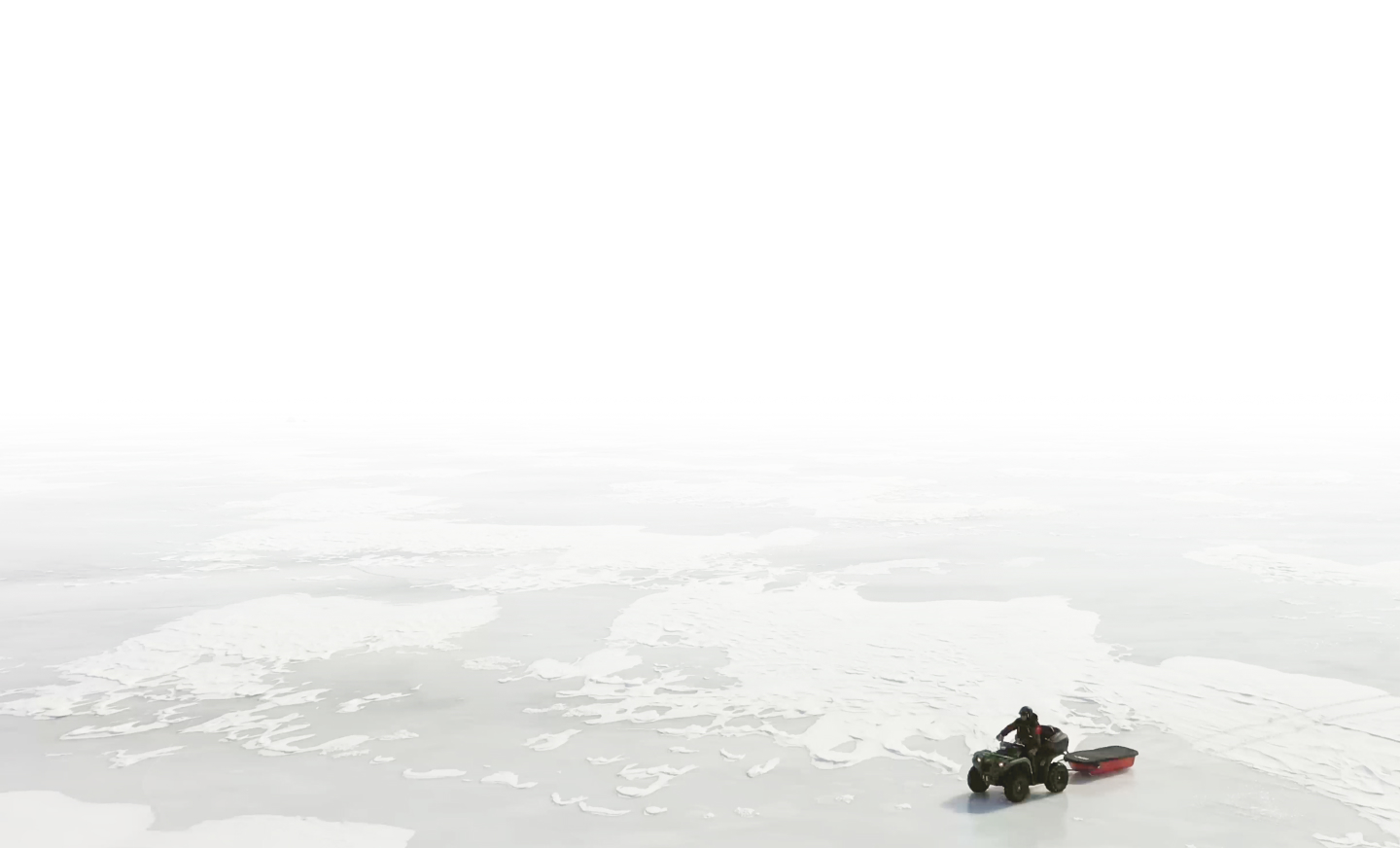 Scott Morrow four-wheeling a storage bin across a lake’s shore.